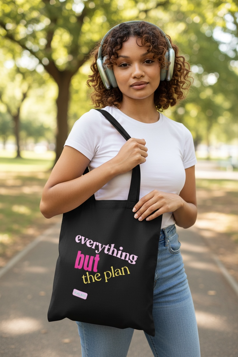 Woman holding a black tote bag with text in a park