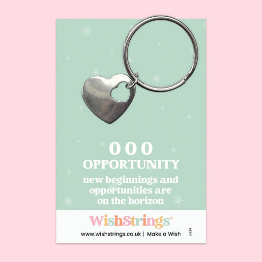 Heart-shaped keychain on a WishStrings branded card with motivational text on a pink background