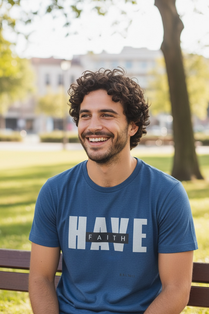 Man wearing a blue t-shirt with 'HAVE FAITH' text, sitting outdoors.