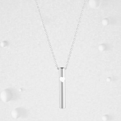 KALMii Anxiety Necklace set against a pale background. Silver pendant with white heart 