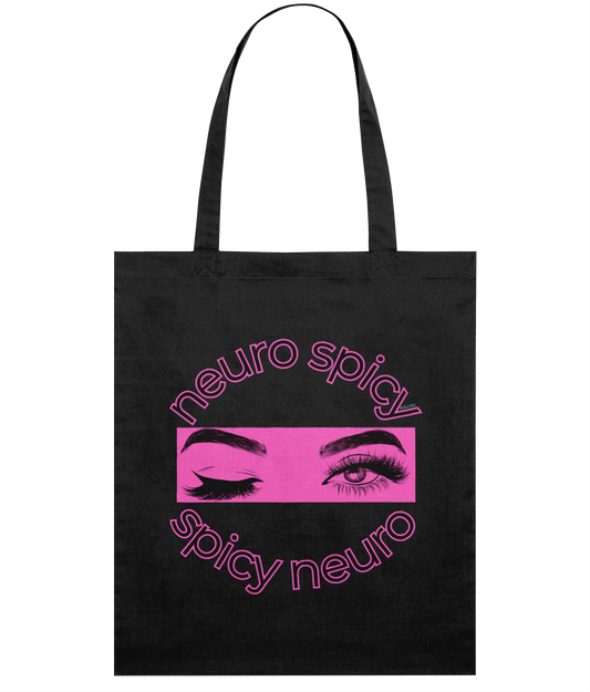 Black tote bag with pink 'neuro spicy' and 'spicy neuro' text and eye graphic on a white background