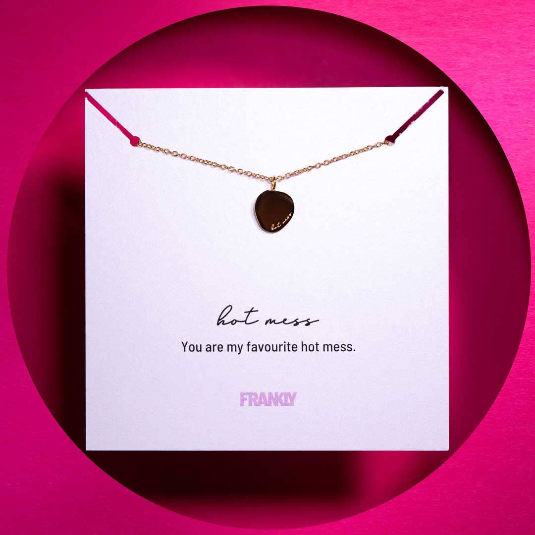 Necklace with heart-shaped pendant on a card with text and 'FRANkLY' branding against a pink background