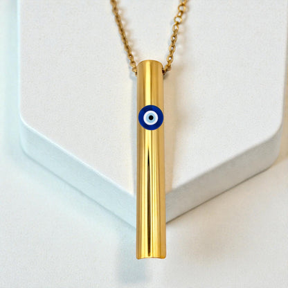 KALMii Gold necklace with a cylindrical pendant featuring an evil eye design on a white background Anxiety necklace